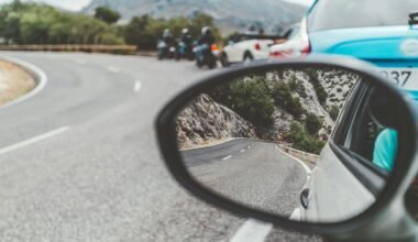 Schwarzer Autospiegel auf Mallorca zeigt vorbeifahrende Autos bei Tageslicht, aufgenommen von Eugene Zhyvchik