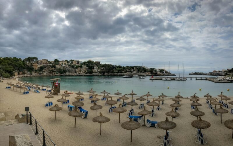 Ein Sonnenschirm liegt am Ufer auf Mallorca, bereit für einen entspannten Tag am Strand, fotografiert von Gary Butterfield.