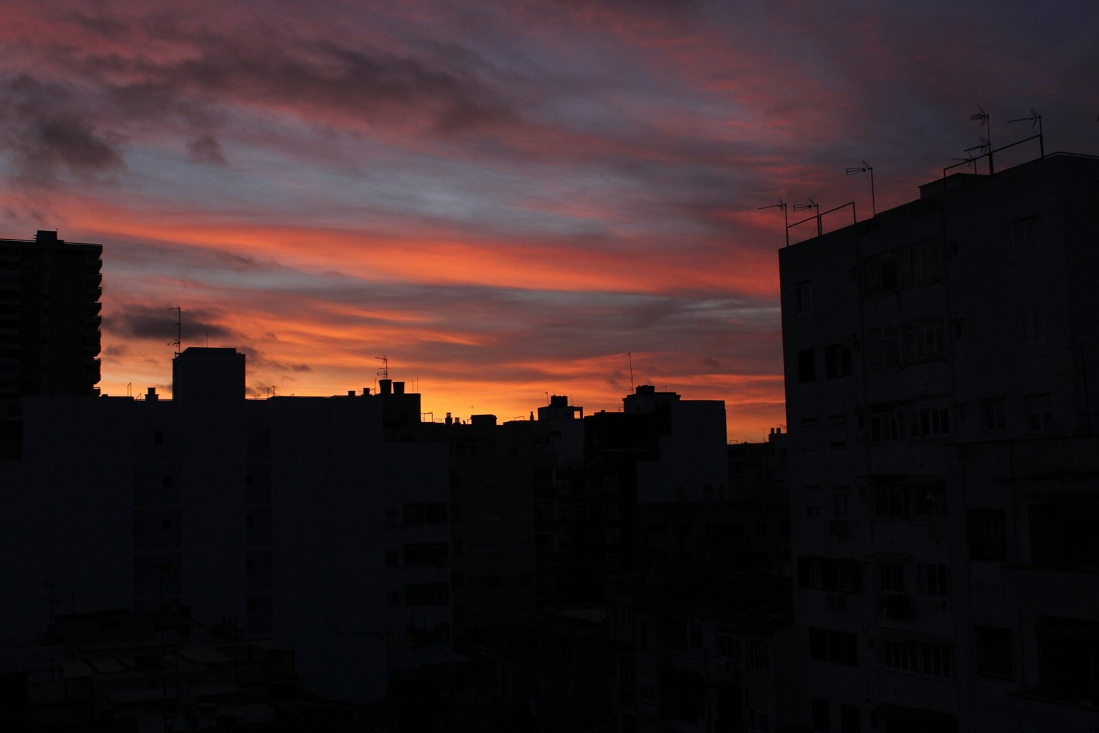 Sonnenuntergang über eine Stadt auf Mallorca, Silhouetten gegen den Himmel, aufgenommen von Susana Bartolome