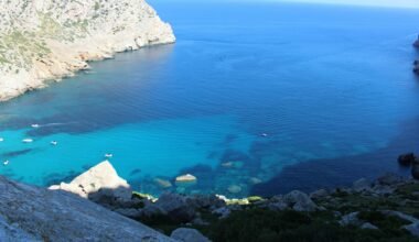 Weiße Felsenformationen nahe dem blauen Meer auf Mallorca bei Tageslicht, aufgenommen von John McFetridge.