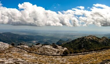 Weiße Wolken ziehen über die braunen Berge auf Mallorca, fotografiert von David Vives.