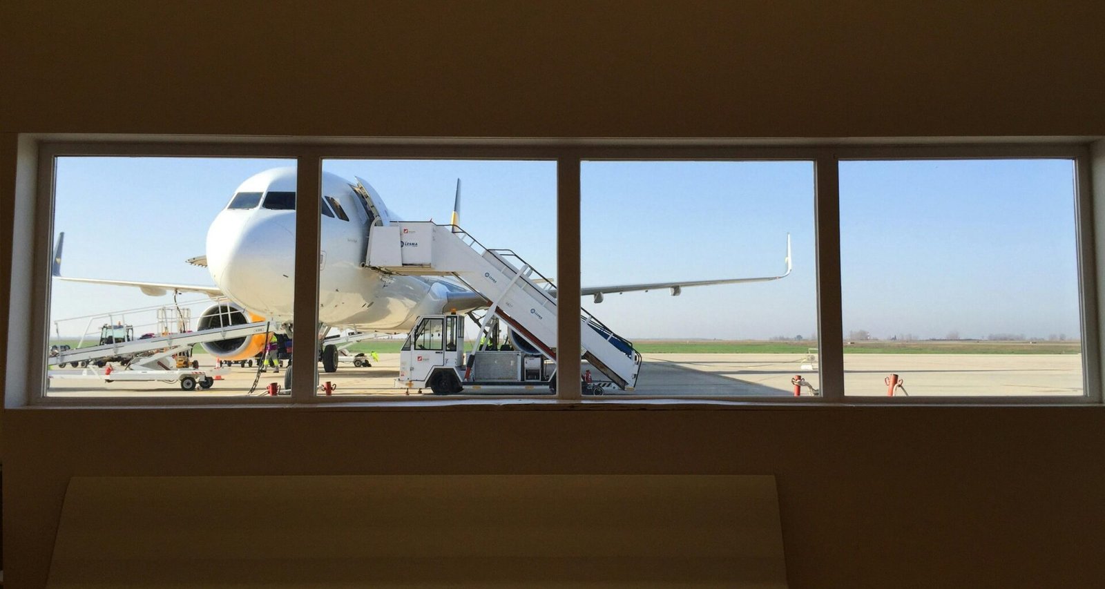 Weißer Lkw neben einem weißen Flugzeug auf Mallorca, aufgenommen von Red Dot, zeigt Transport und Logistik auf der Insel.