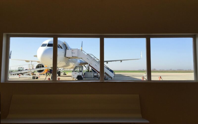 Weißer Lkw neben einem weißen Flugzeug auf Mallorca, aufgenommen von Red Dot, zeigt Transport und Logistik auf der Insel.