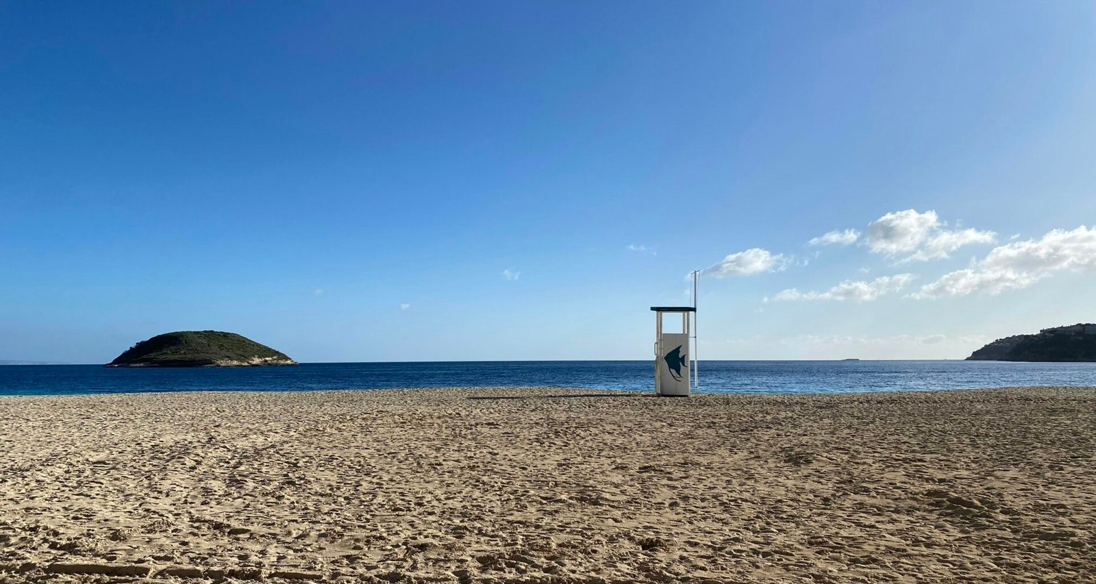 Weiße und braune Holzstruktur auf weißem Sandstrand auf Mallorca bei Tageslicht, aufgenommen von Eveline Rossi