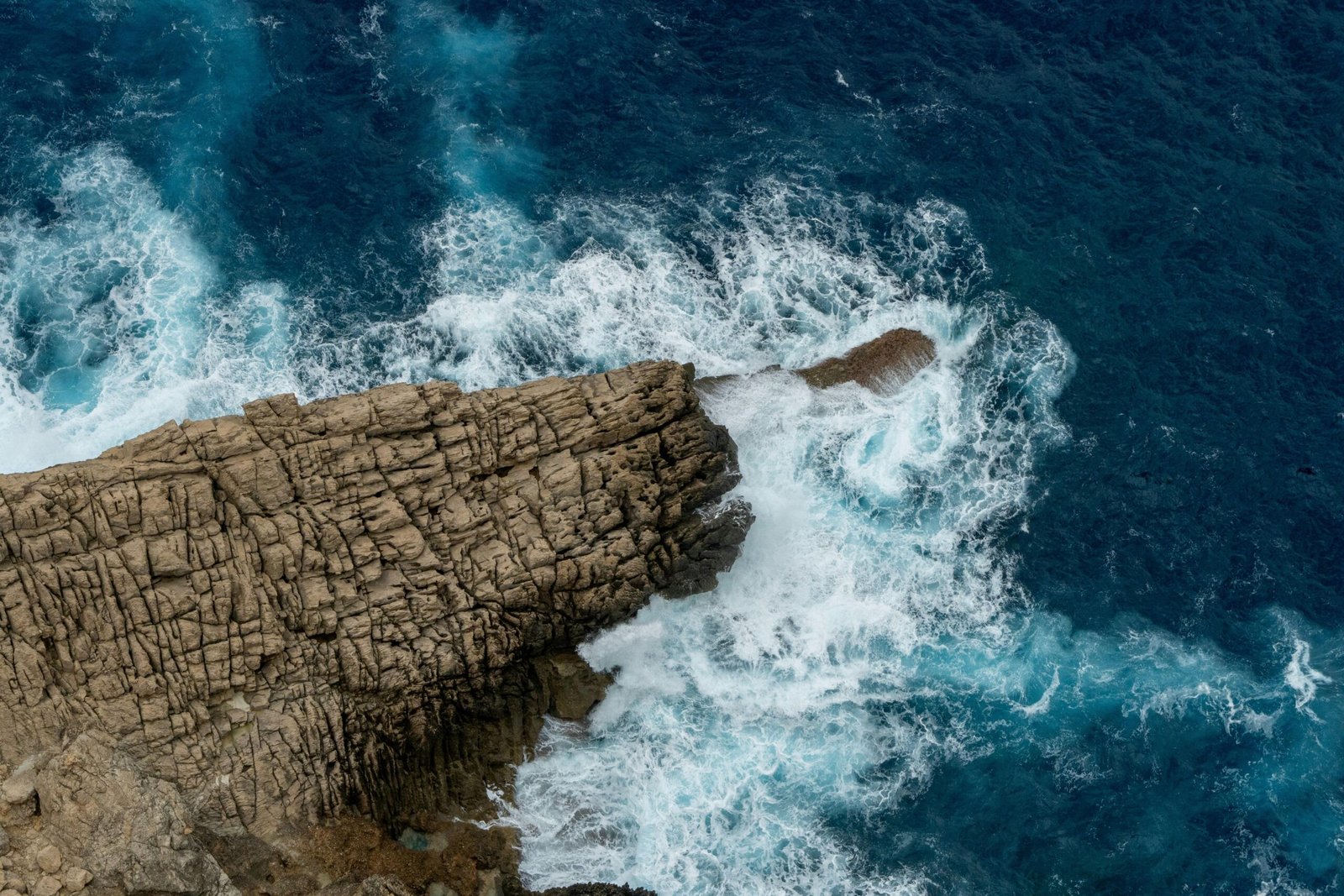 Wellen prallen an einer felsigen Klippe auf Mallorca ab, aufgenommen von Victor Rosario.