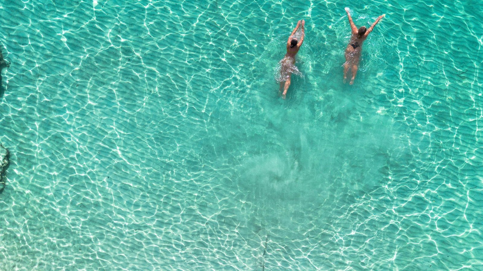 Zwei Frauen schwimmen im türkisen Wasser auf Mallorca, aufgenommen von Arthur Charles Pratt