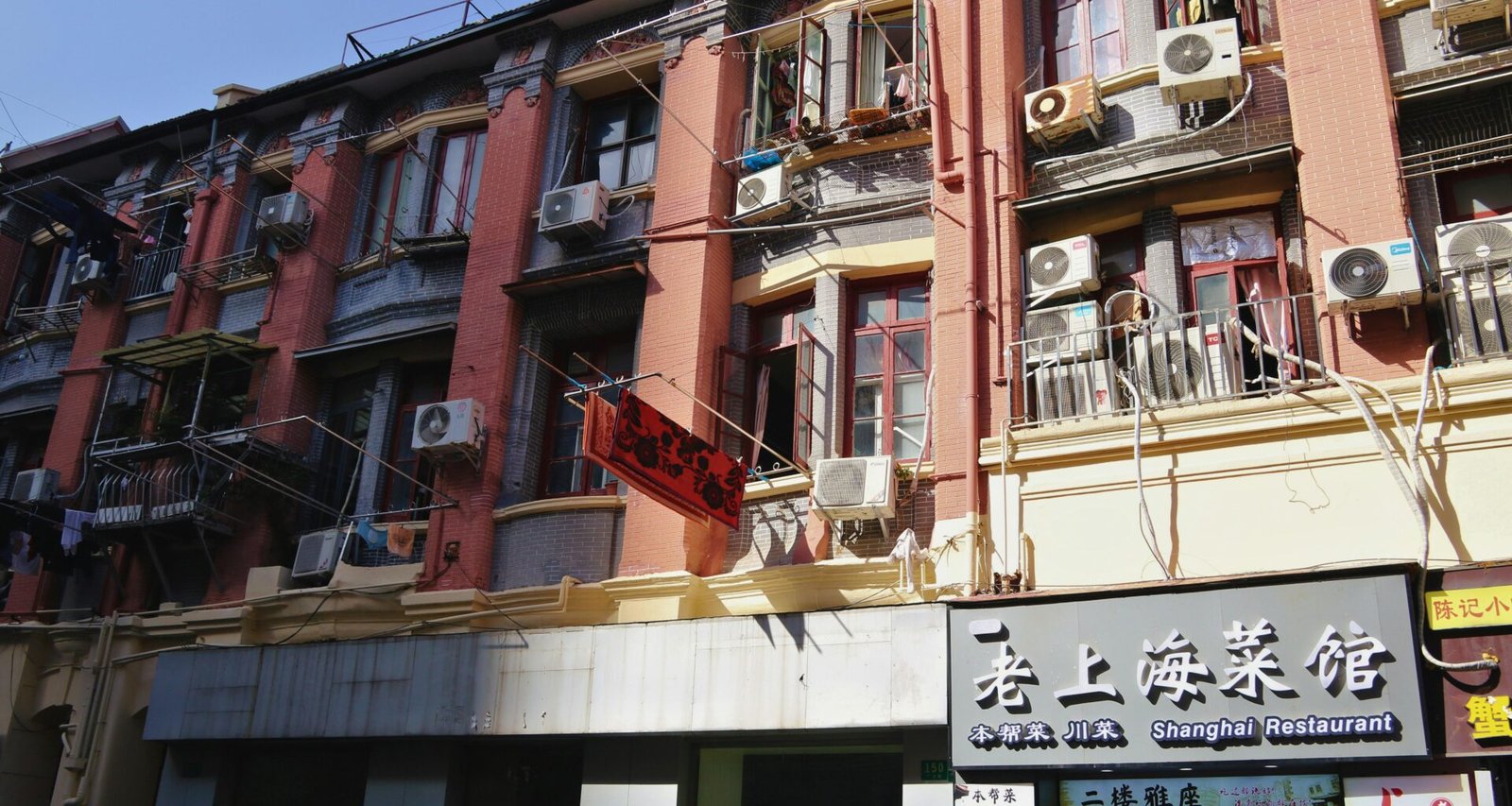 Alte Gebäude auf Mallorca mit vielen Klimaanlagen und Werbeschildern, typisch für das urbane Stadtbild.