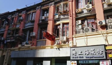 Alte Gebäude auf Mallorca mit vielen Klimaanlagen und Werbeschildern, typisch für das urbane Stadtbild.