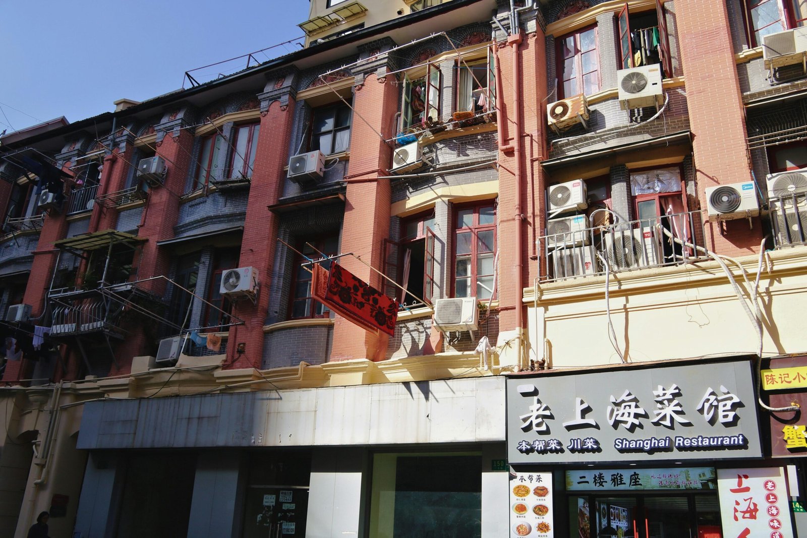 Alte Gebäude auf Mallorca mit vielen Klimaanlagen und Werbeschildern, typisch für das urbane Stadtbild.