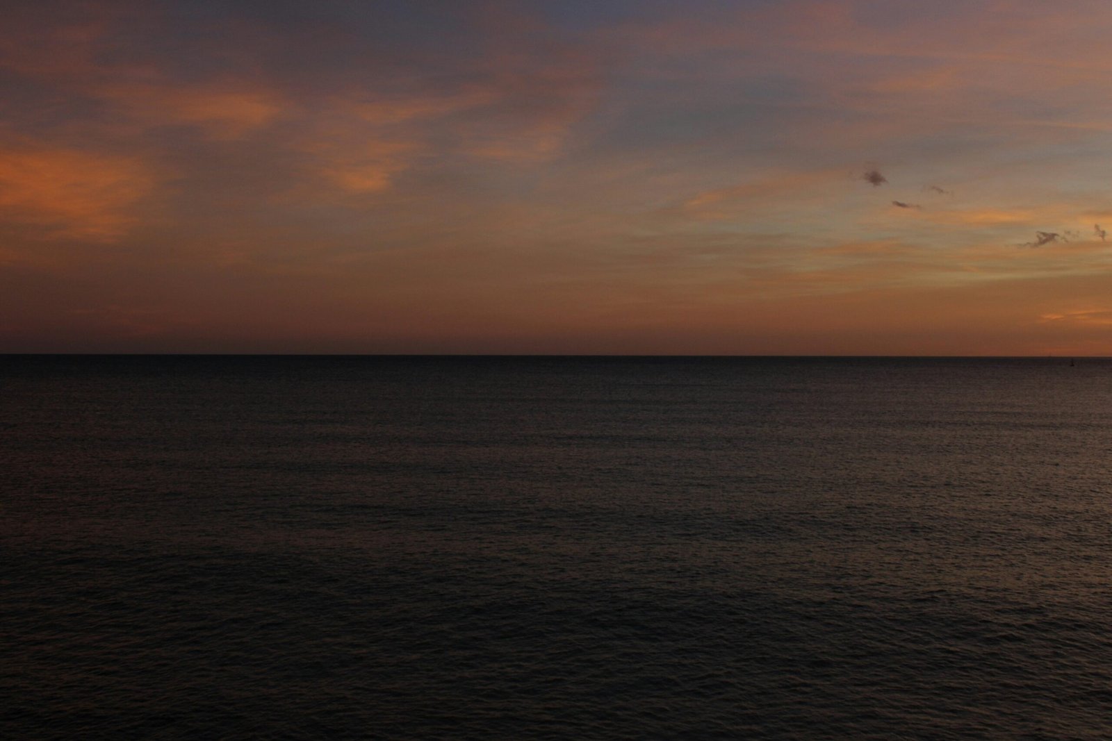Der Sonnenuntergang malt den Himmel über dem dunklen Meer auf Mallorca, fotografiert von Susana Bartolome.