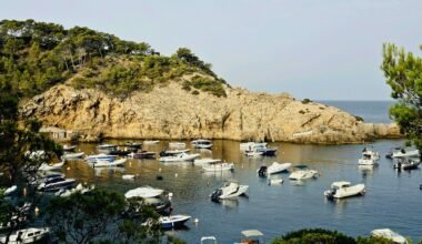 Boote liegen in einem ruhigen Hafen auf Mallorca, umgeben von stiller Wasseroberfläche und Naturkulisse