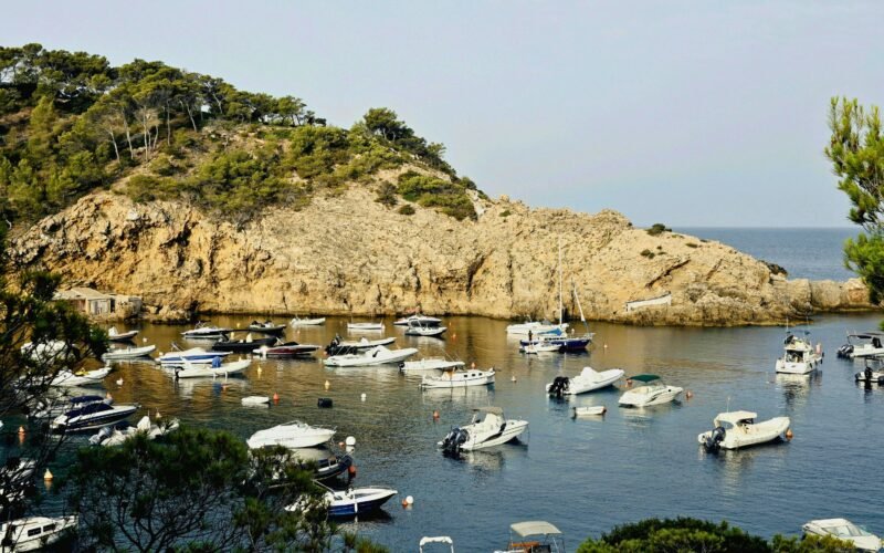 Boote liegen in einem ruhigen Hafen auf Mallorca, umgeben von stiller Wasseroberfläche und Naturkulisse