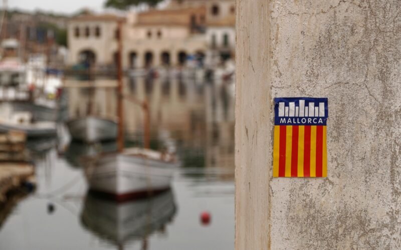 Sticker an einer Wand nahe eines Hafens auf Mallorca, aufgenommen von Alex Kulikov
