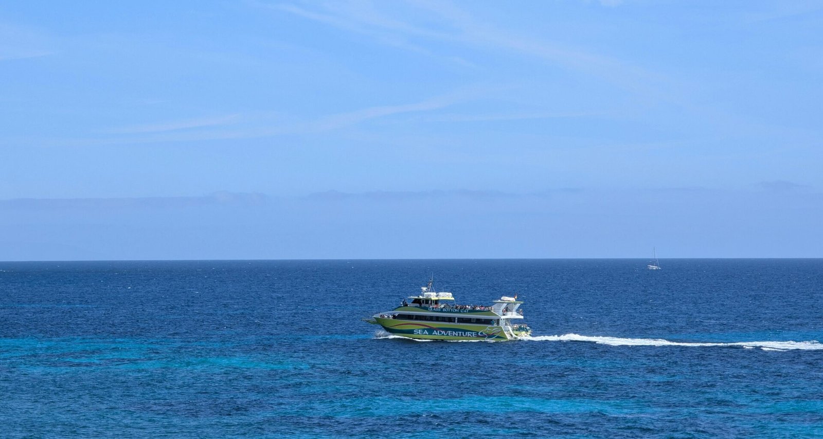 Ein Boot fährt über das strahlend blaue Wasser auf Mallorca, aufgenommen von David Vives.
