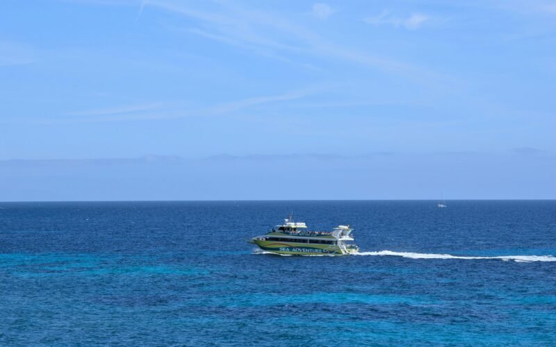 Ein Boot fährt über das strahlend blaue Wasser auf Mallorca, aufgenommen von David Vives.