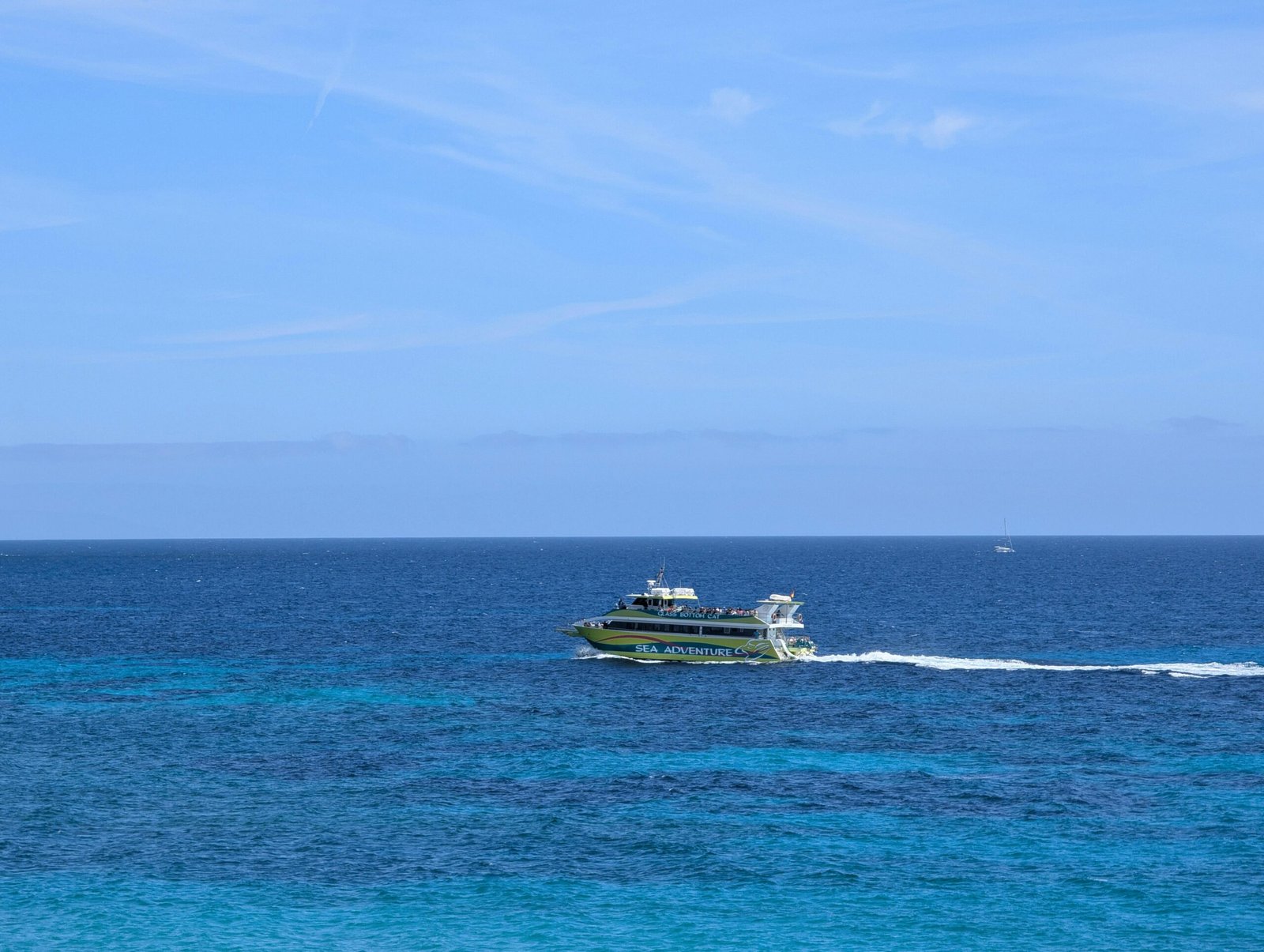 Ein Boot fährt über das strahlend blaue Wasser auf Mallorca, aufgenommen von David Vives.