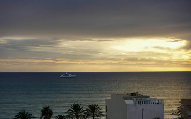 Boot auf Mallorca unterwegs im offenen Meer an einem bewölkten Tag, fotografiert von Yan Ots