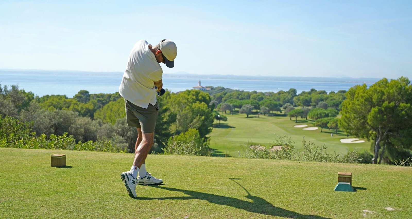 Mann schwingt einen Golfschläger auf einem Golfplatz auf Mallorca, aufgenommen von Frederik Rosar.