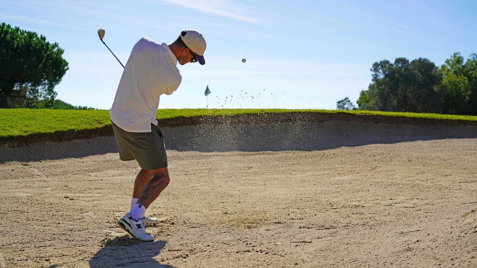 Mann spielt Golf auf Mallorca an einem sonnigen Tag, umgeben von grünen Fairways und blauen Himmel.