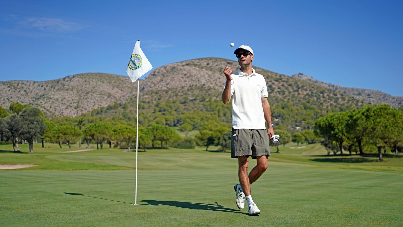 Mann steht auf einem grünen Golfplatz auf Mallorca und schaut in die Ferne, aufgenommen von Frederik Rosar