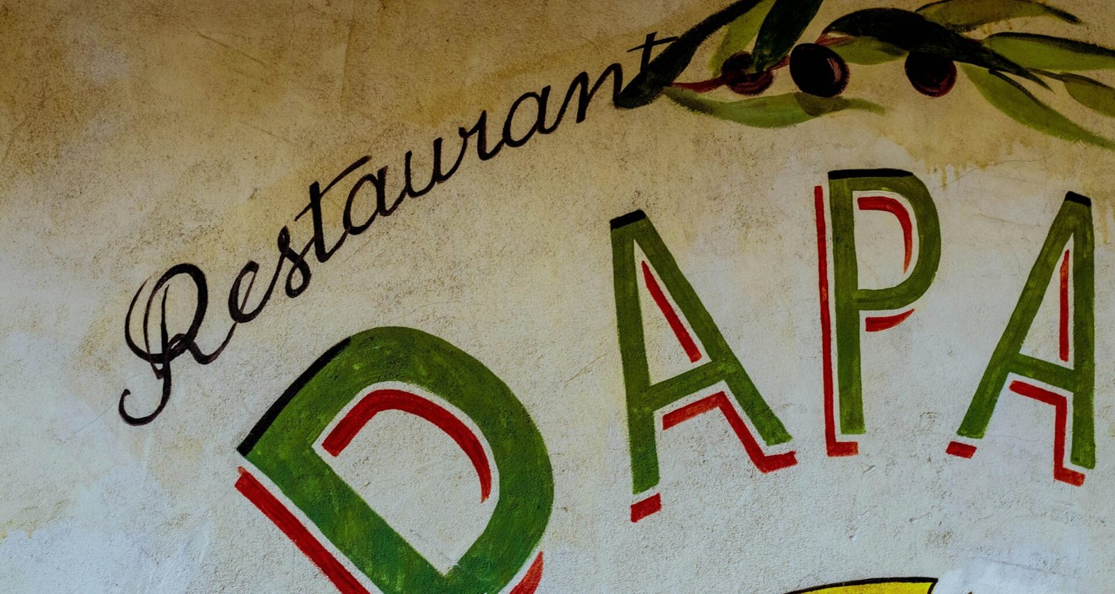 Restaurant-Schild auf Mallorca auf einer Gebäudewand, fotografiert von DDP, zeigt die lokale Gastronomie der Insel.