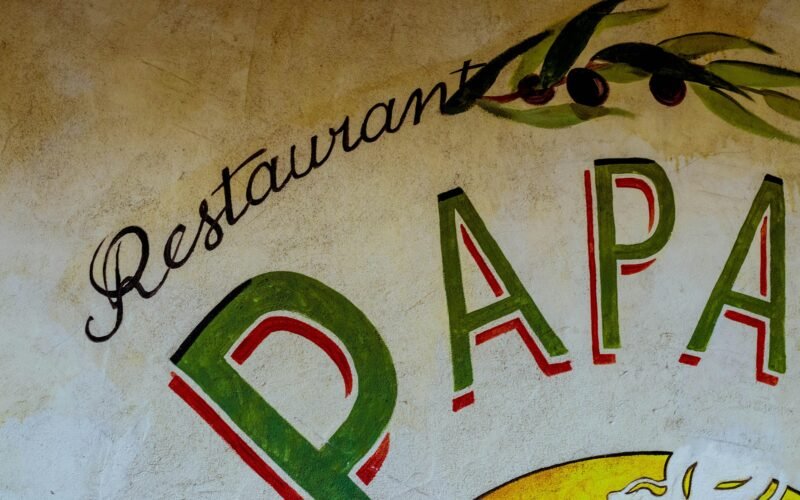 Restaurant-Schild auf Mallorca auf einer Gebäudewand, fotografiert von DDP, zeigt die lokale Gastronomie der Insel.