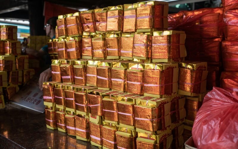 Haufen von orange verpackten Paketen auf Mallorca, die auf einem Tresen liegen, fotografiert von Charles Chen
