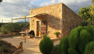 Steingebäude mit Terrasse und Sonnenschirm auf Mallorca, aufgenommen von Sara Sadeghloo