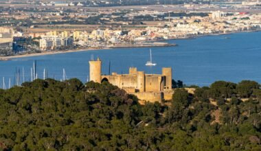 Burg auf Mallorca auf einem Hügel mit Blick auf das Wasser, aufgenommen von David Vives.