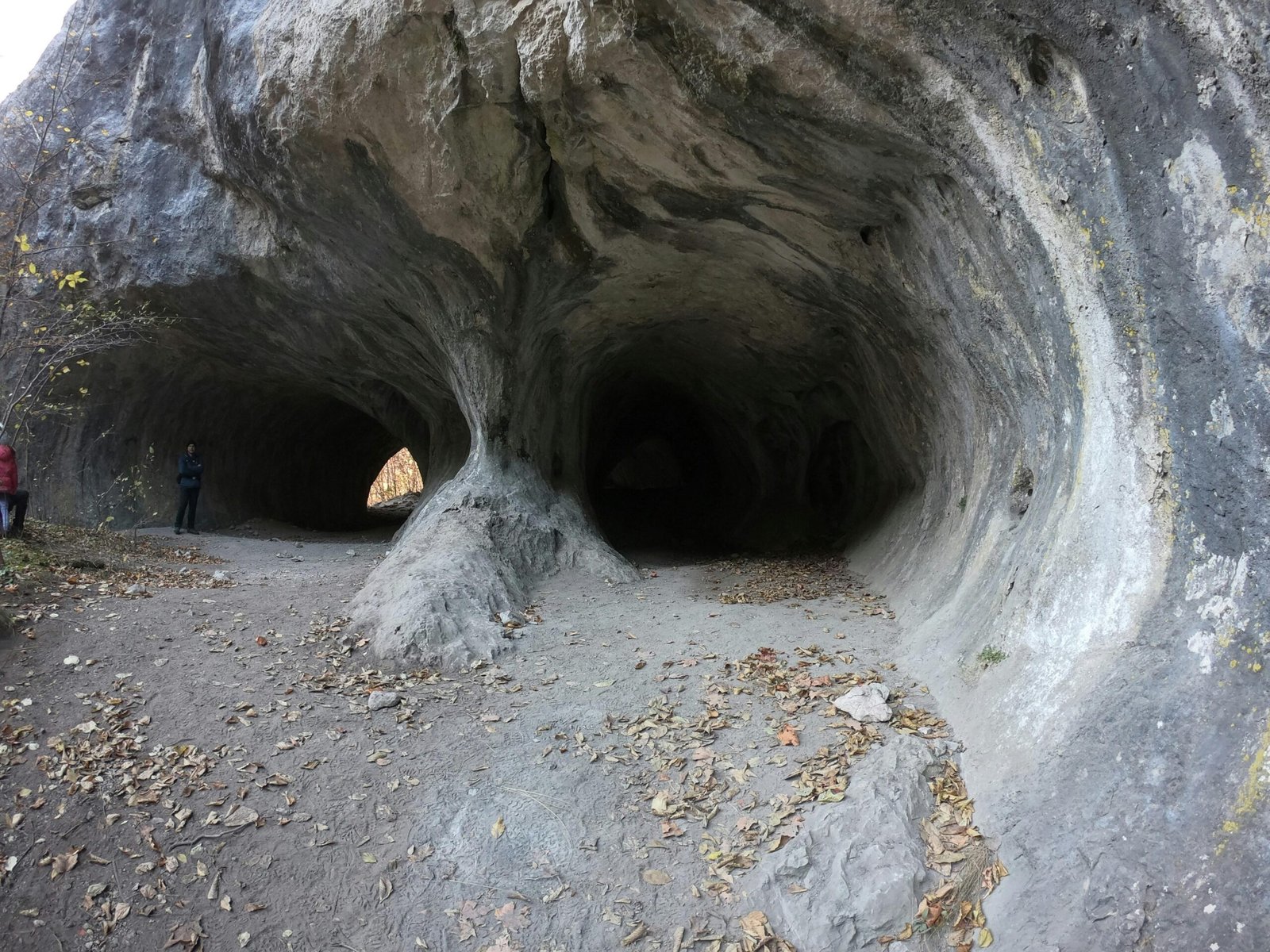 Gruppe von Menschen steht in einer Höhle auf Mallorca, erkundet die unterirdische Umgebung, aufgenommen von Vladut Tomsa.