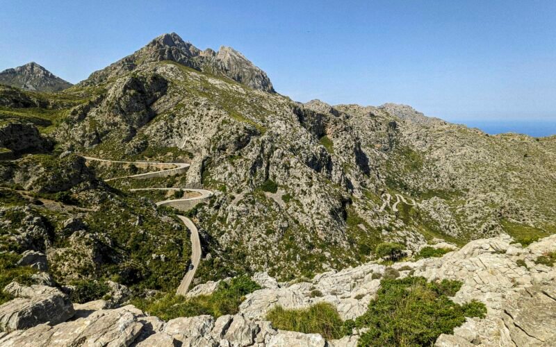 Kurvige Straße in den Bergen auf Mallorca bei sonnigem Wetter, aufgenommen von Andre Blanco.