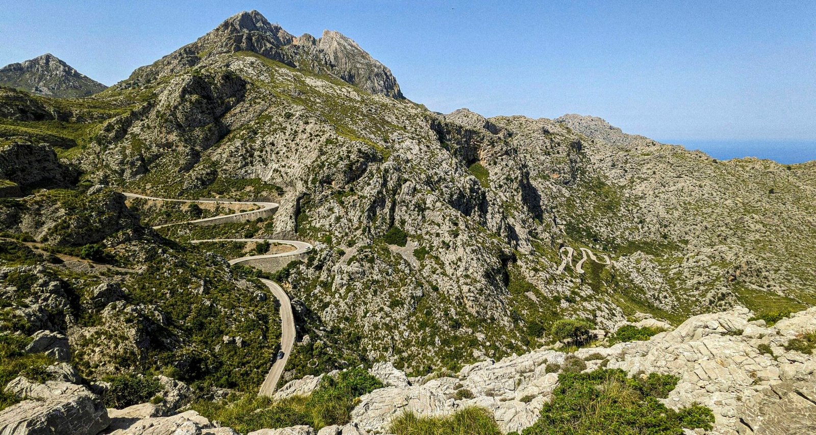 Kurvige Straße in den Bergen auf Mallorca bei Sonnenschein, aufgenommen von Andre Blanco.