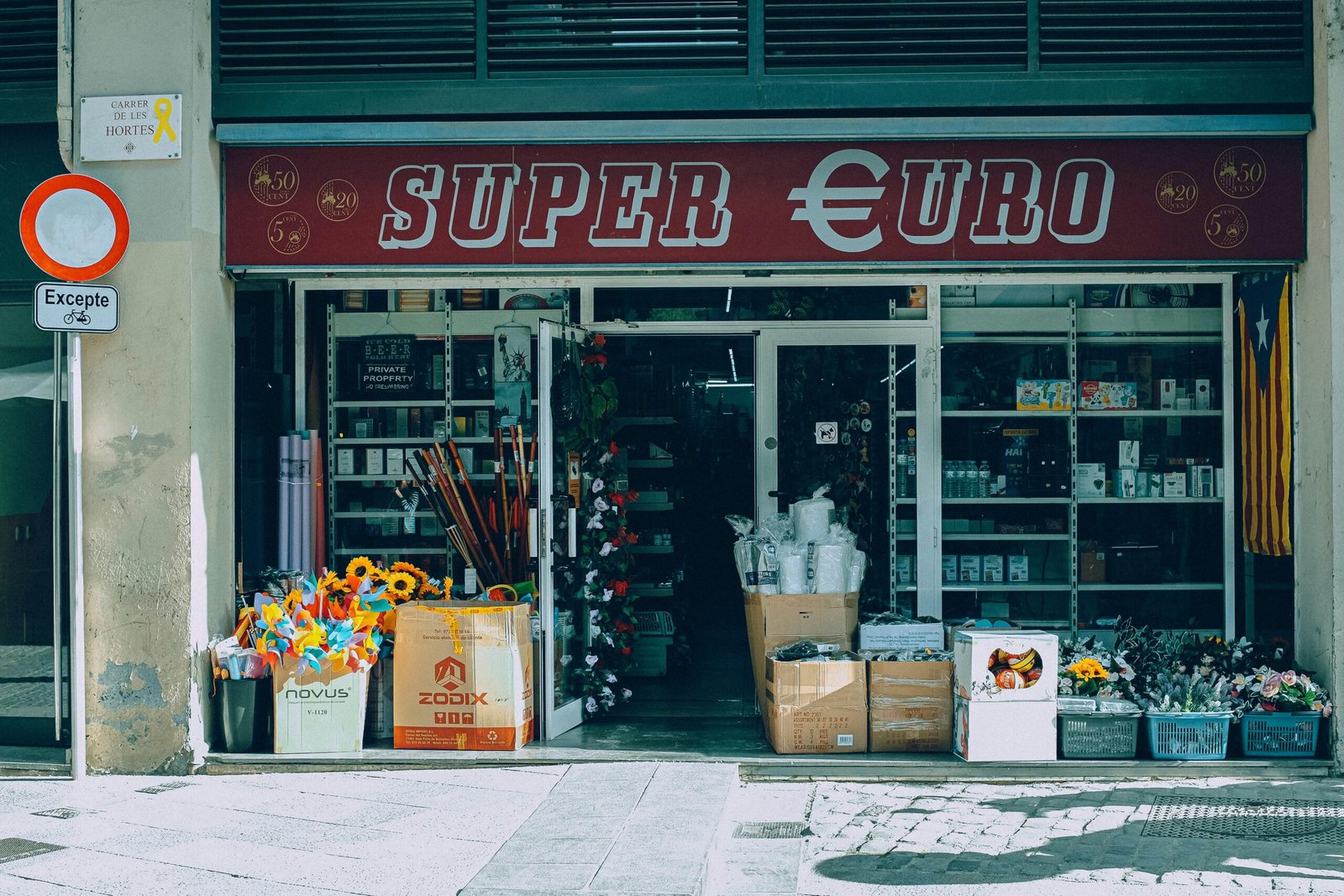 Ein Laden auf Mallorca mit einem Blumenstrauß vor dem Eingang, aufgenommen von INFOE Studio.