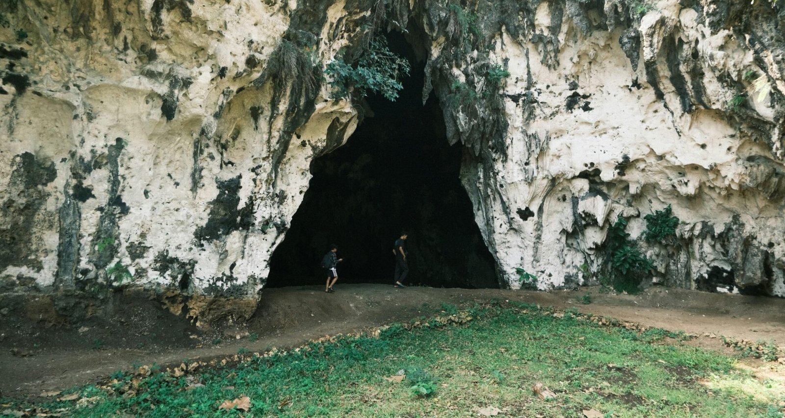 Person steht mit Fahrrad in einer Höhle auf Mallorca, erkundet die unterirdische Umgebung