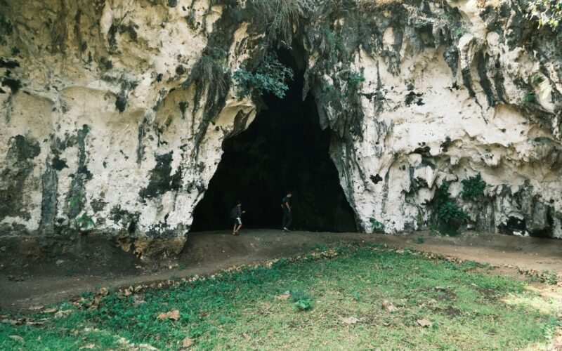 Person steht mit Fahrrad in einer Höhle auf Mallorca, erkundet die unterirdische Umgebung
