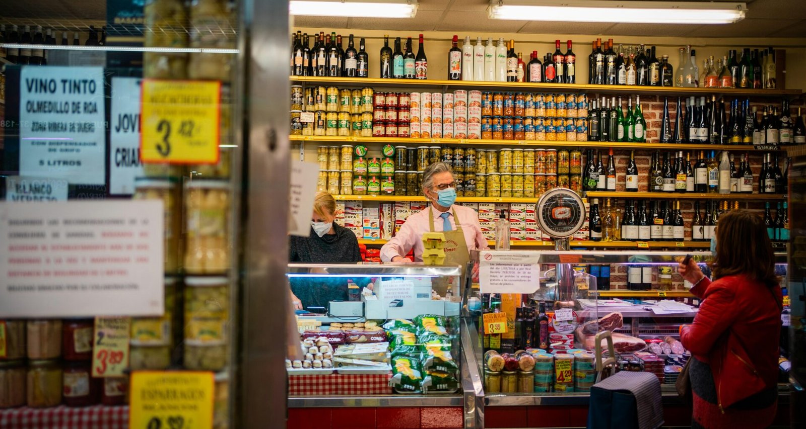 Frau in pinkem Polo steht vor einem Laden auf Mallorca, fotografiert von Victoriano Izquierdo.