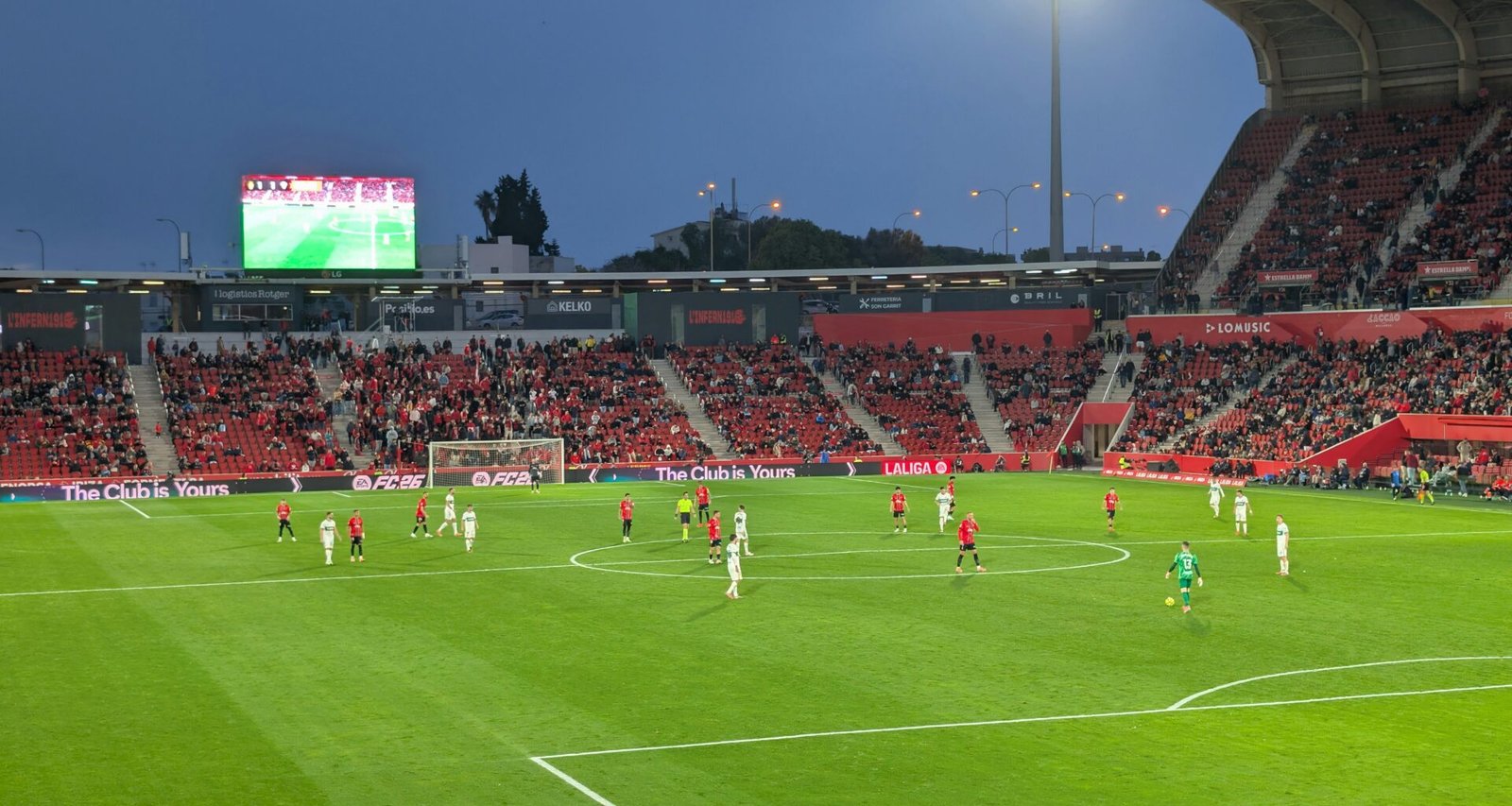 Fußballspiel in einem Stadion auf Mallorca bei Dämmerung, Spieler im Einsatz während des Spiels