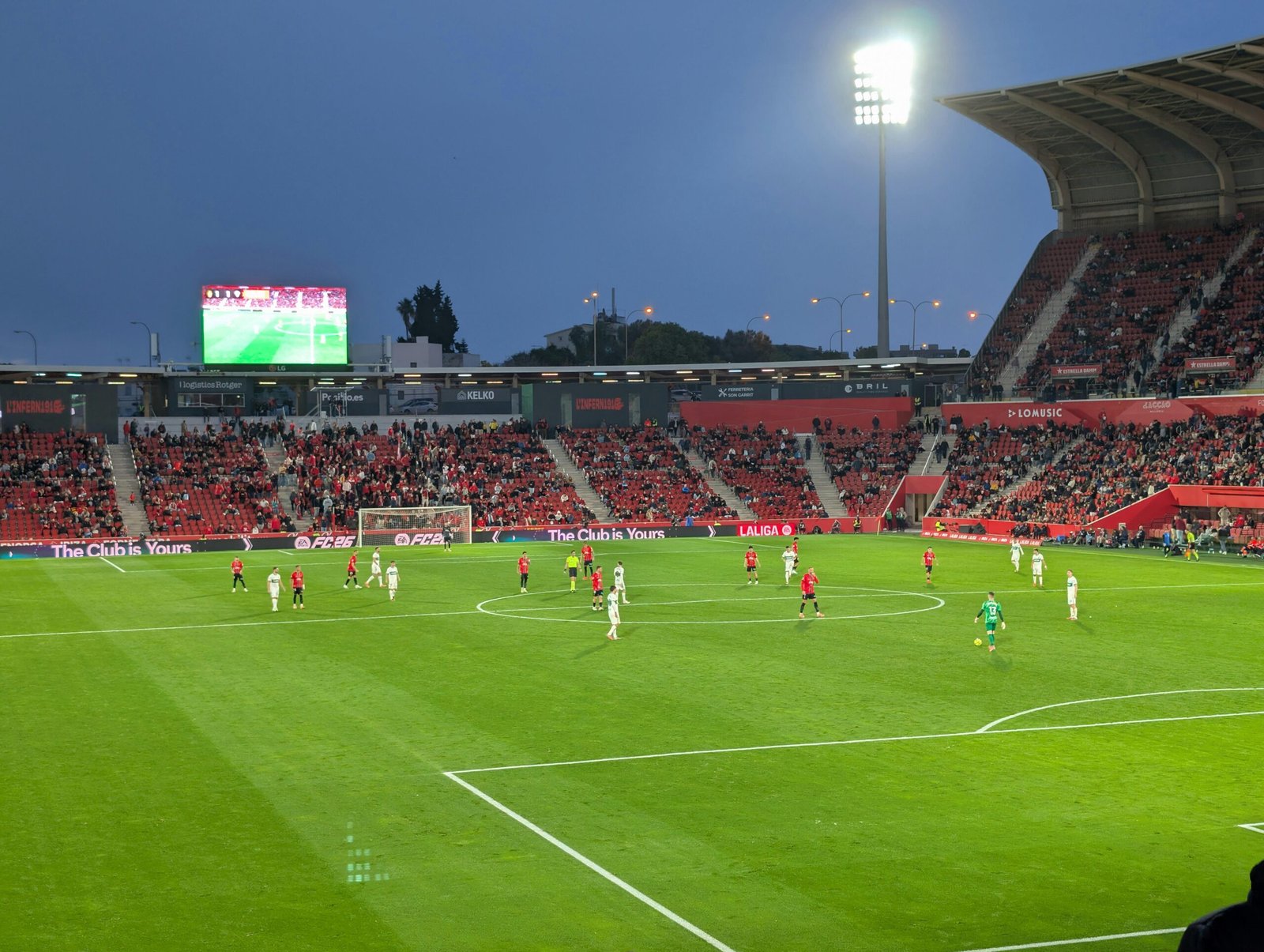 Fußballspiel in einem Stadion auf Mallorca bei Dämmerung, Spieler im Einsatz während des Spiels