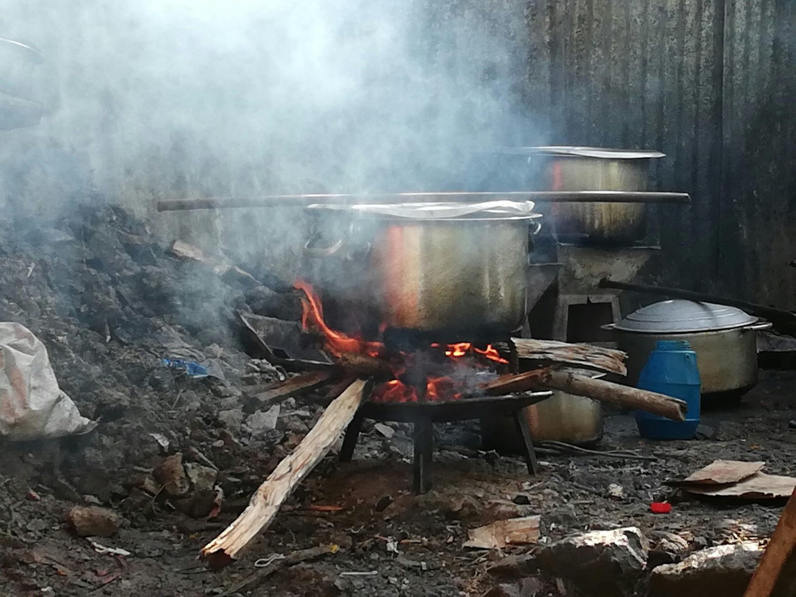 Grauer Metallkochtopf auf Mallorca auf einem Holzfeuer, das zum traditionellen Kochen genutzt wird