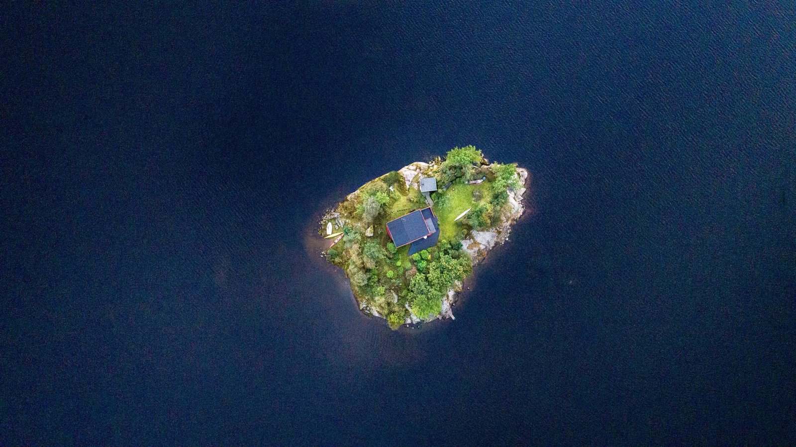 Luftaufnahme eines blauen Gebäudes in der Mitte einer Insel auf Mallorca, aufgenommen von Thomas Griesbeck