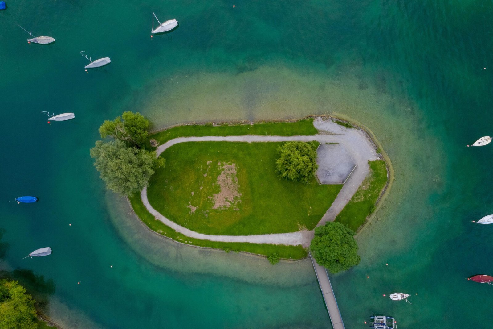 Luftaufnahme eines grünen Grasfeldes und eines Wasserbeckens auf Mallorca, aufgenommen von Patrick Federi.