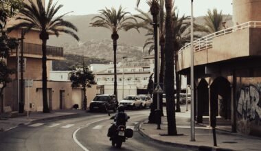 Mann fährt mit Motorrad auf Mallorca entlang einer Straße bei Tageslicht, umgeben von Natur
