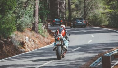 Motorradfahrer in rotem und weißem Anzug fährt auf Mallorca bei Tageslicht auf der Straße