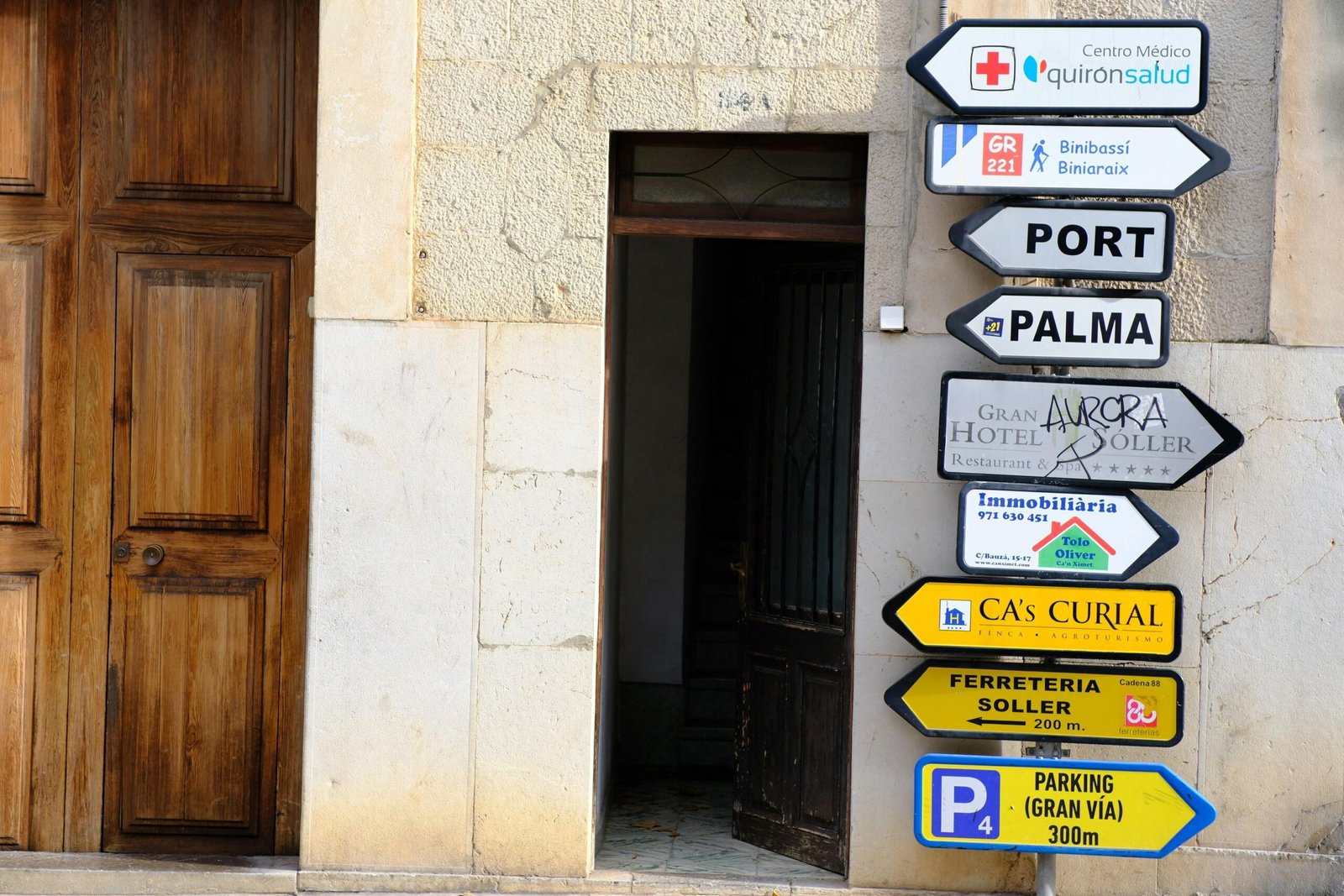 Straßenschilder auf Mallorca zeigen Richtungen zu verschiedenen Orten und Dienstleistungen, aufgenommen von Sascha Braun.