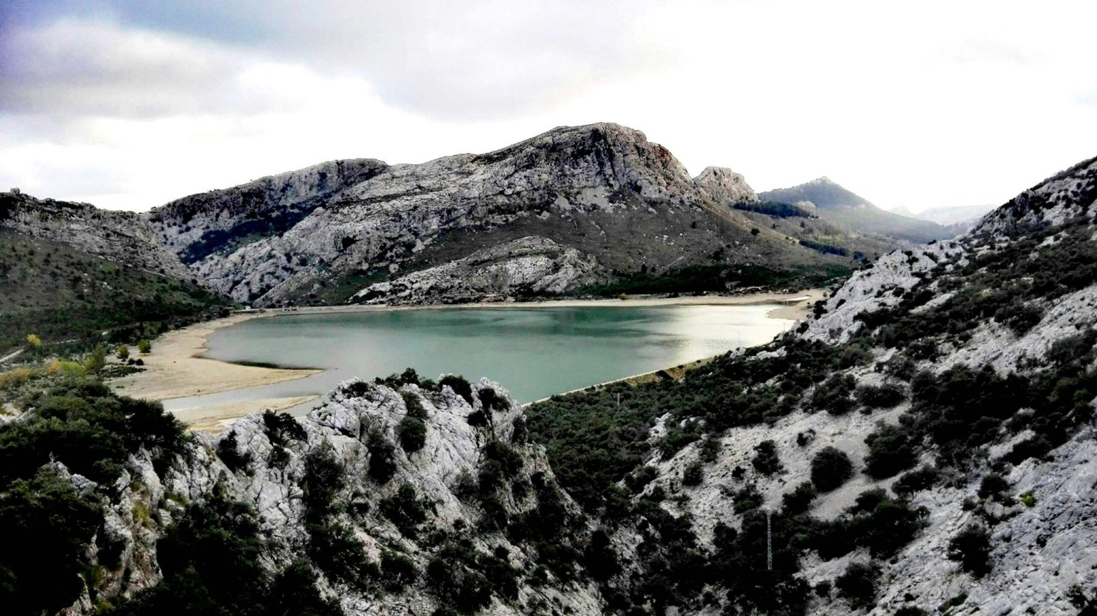 See in den Bergen auf Mallorca bei Tageslicht, umgeben von Natur und Felsen, aufgenommen von Doloresz Dombi