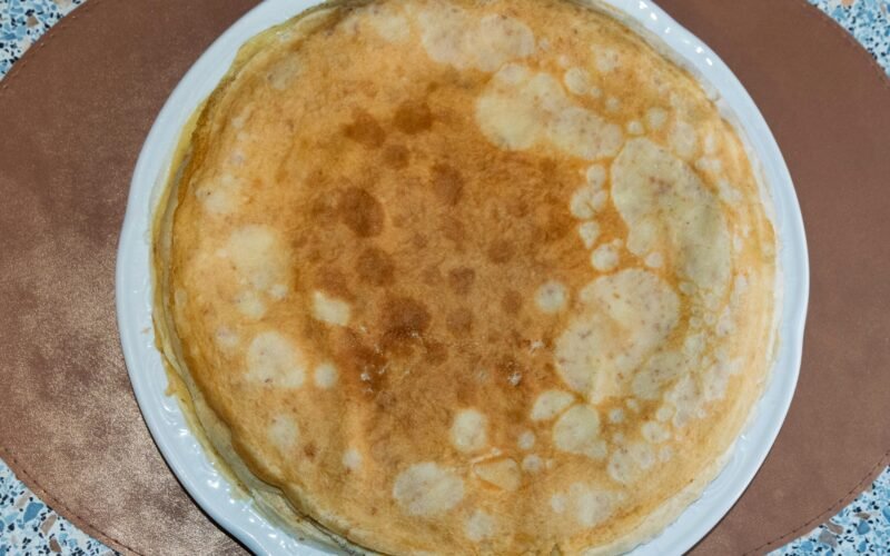 Stack aus goldenen Crêpes auf weißem Teller, fotografiert von Sergej Karpow auf Mallorca.