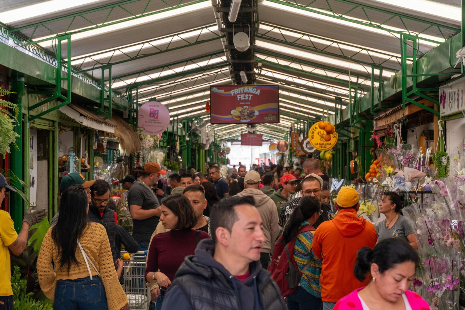 Gedrängter Innenmarkt auf Mallorca mit Ständen und Einkäufern, fotografiert von Reza Madani.