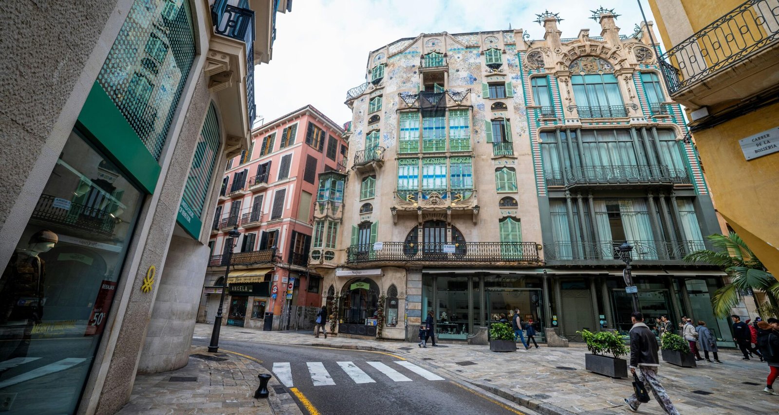 Ornate Gebäude entlang einer kopfsteingepflasterten Straße mit Zebrastreifen auf Mallorca, aufgenommen von Viacheslav Poturaev.