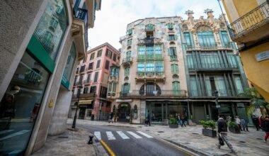 Ornate Gebäude entlang einer gepflasterten Straße mit Zebrastreifen auf Mallorca, fotografiert von Viacheslav Poturaev