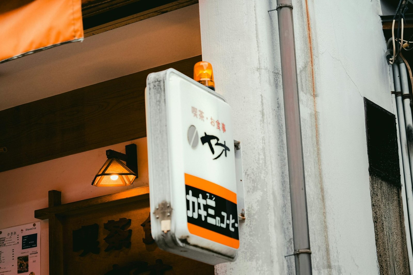 Weißes Schild mit orangefarbenen Akzenten und japanischem Text auf Mallorca, fotografiert von Johnny Ho